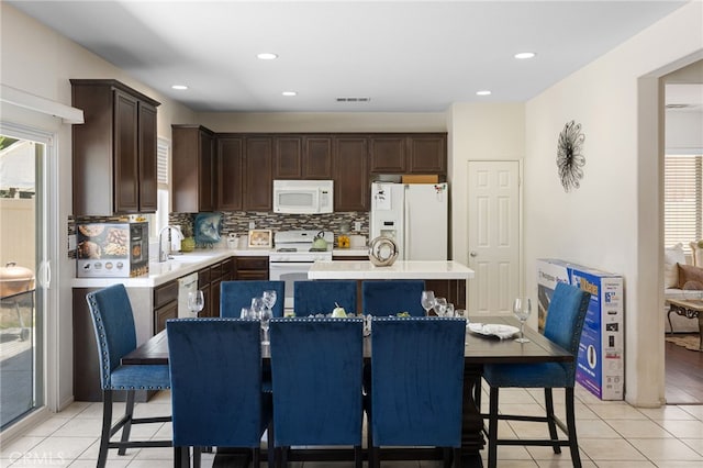 544 W Elm Park Ave, Rialto, CA 92376 - kitchen featuring white appliances, dark brown cabinets, a center island, backsplash, and light tile patterned flooring
