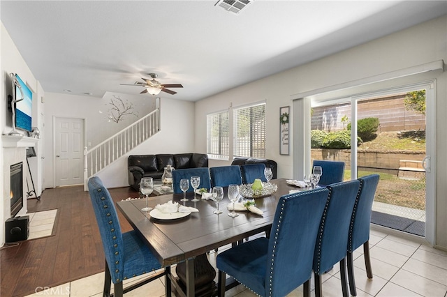 544 W Elm Park Ave, Rialto, CA 92376 - dining space featuring stairs, ceiling fan, a fireplace with flush hearth, and light wood finished floors