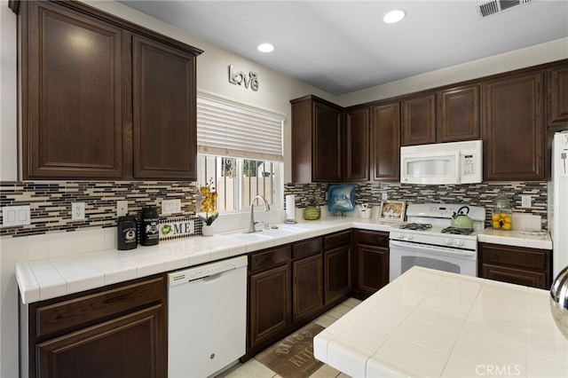 544 W Elm Park Ave, Rialto, CA 92376 - kitchen featuring white appliances, dark brown cabinetry, decorative backsplash, recessed lighting, and tile countertops