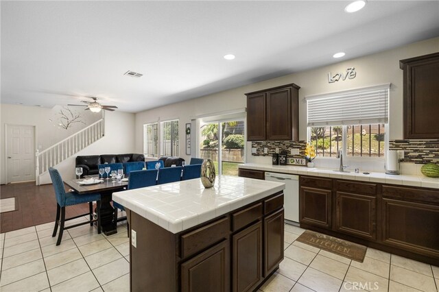 544 W Elm Park Ave, Rialto, CA 92376 - kitchen with white dishwasher, tile counters, decorative backsplash, dark brown cabinets, and light tile patterned floors