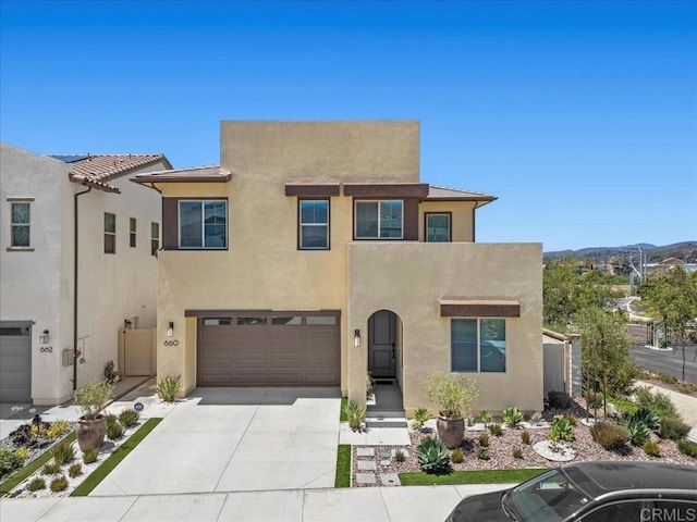 660 Westbrook Loop, San Marcos, CA 92078 - view of front facade with stucco siding, concrete driveway, a garage, and a mountain view