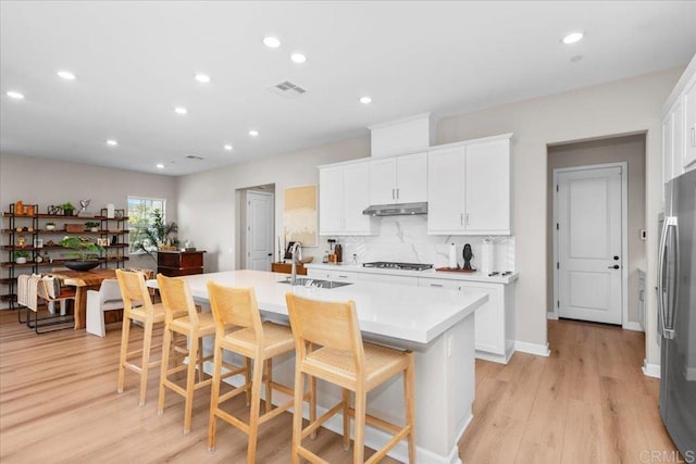 660 Westbrook Loop, San Marcos, CA 92078 - kitchen with stainless steel appliances, light countertops, an island with sink, light wood finished floors, and recessed lighting