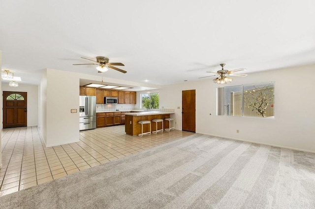 2239 Sunset Dr, Escondido, CA 92025 - kitchen featuring appliances with stainless steel finishes, light countertops, brown cabinetry, and ceiling fan