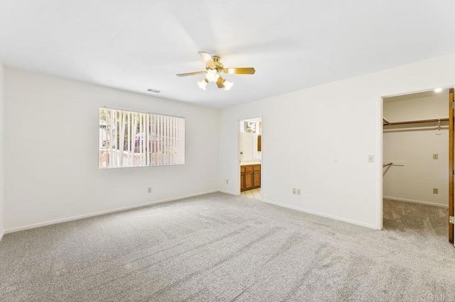2239 Sunset Dr, Escondido, CA 92025 - unfurnished bedroom featuring light carpet, a spacious closet, ceiling fan, ensuite bathroom, and a closet