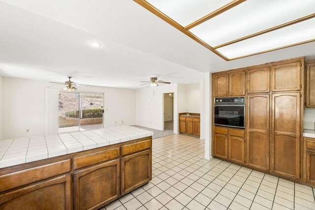2239 Sunset Dr, Escondido, CA 92025 - kitchen with oven, ceiling fan, tile countertops, brown cabinets, and recessed lighting