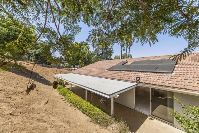 2239 Sunset Dr, Escondido, CA 92025 - view of home's exterior featuring roof mounted solar panels, a tiled roof, and stucco siding
