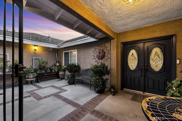 7951 Woodlake Ave, West Hills, CA 91304 - exterior entry at dusk with stucco siding and a patio area