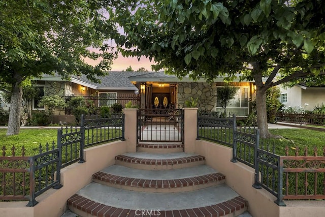 7951 Woodlake Ave, West Hills, CA 91304 - view of front of house featuring a fenced front yard, stone siding, and a gate