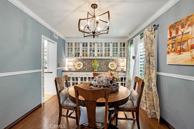 7951 Woodlake Ave, West Hills, CA 91304 - dining area with dark wood finished floors, a chandelier, and ornamental molding