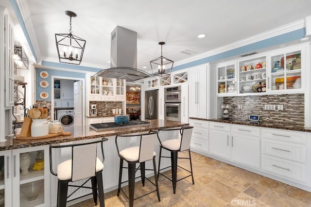 7951 Woodlake Ave, West Hills, CA 91304 - kitchen featuring island exhaust hood, a chandelier, appliances with stainless steel finishes, stacked washer / dryer, and backsplash