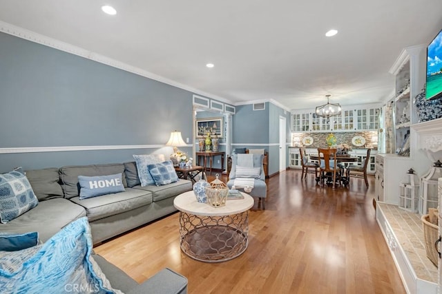 7951 Woodlake Ave, West Hills, CA 91304 - living room featuring a chandelier, wood finished floors, ornamental molding, and recessed lighting