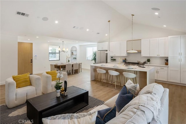 20109 Archwood St, Winnetka, CA 91306 - living room with light wood-type flooring, a chandelier, and high vaulted ceiling