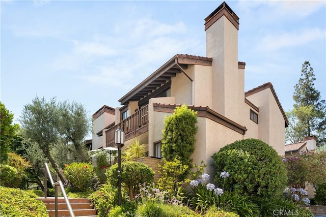 21730 Marylee St Unit 29, Woodland Hills, CA 91367 - view of side of property featuring a chimney, stucco siding, and a tile roof