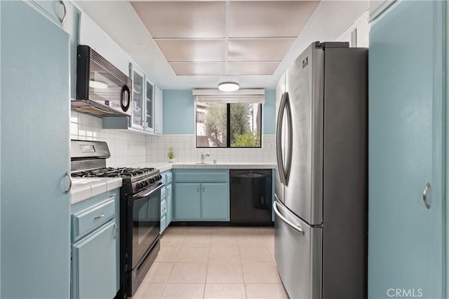 21730 Marylee St Unit 29, Woodland Hills, CA 91367 - kitchen featuring black appliances, tile counters, backsplash, and light tile patterned floors