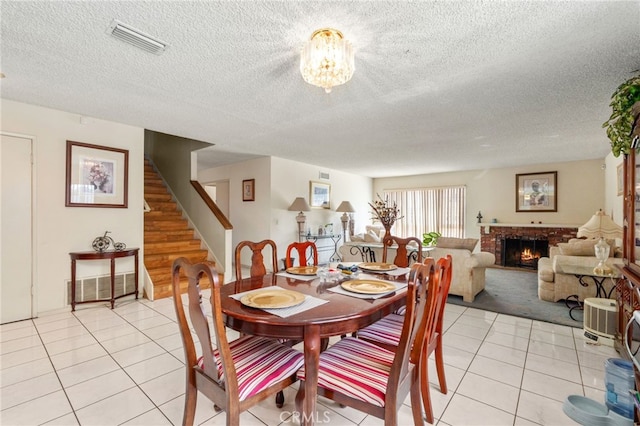 19722 Tajauta Ave, Carson, CA 90746 - dining space with light tile patterned floors, stairway, a fireplace, and a textured ceiling