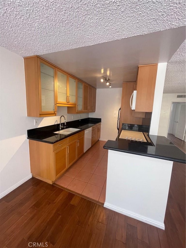 5328 Newcastle Ave Unit 26, Encino, CA 91316 - kitchen featuring white appliances, a textured ceiling, dark wood-style flooring, glass insert cabinets, and dark countertops