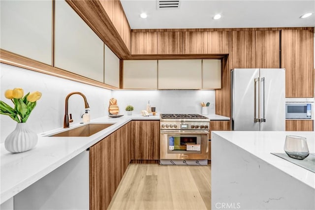 1027 N Lamer St, Burbank, CA 91506 - kitchen with premium appliances, modern cabinets, brown cabinetry, light wood-style flooring, and recessed lighting