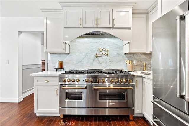 229 S Kingsley Dr, Los Angeles, CA 90004 - kitchen featuring appliances with stainless steel finishes, dark wood-type flooring, light stone countertops, and backsplash
