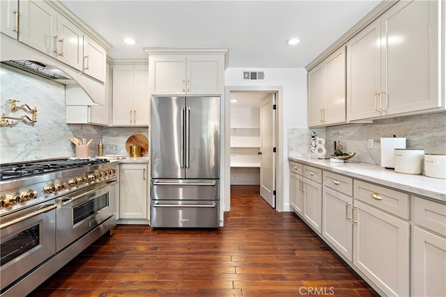 229 S Kingsley Dr, Los Angeles, CA 90004 - kitchen featuring high end appliances, tasteful backsplash, dark wood-type flooring, light stone countertops, and recessed lighting