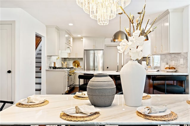 229 S Kingsley Dr, Los Angeles, CA 90004 - kitchen with a chandelier, appliances with stainless steel finishes, tasteful backsplash, white cabinets, and recessed lighting