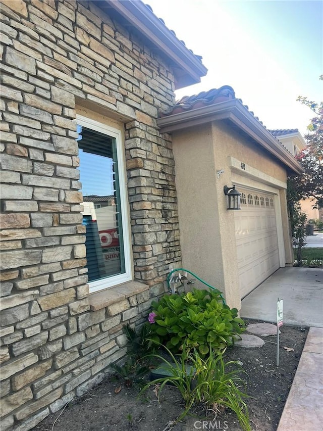 4630 Via Dulce, Camarillo, CA 93012 - view of side of home with stone siding, concrete driveway, an attached garage, and stucco siding