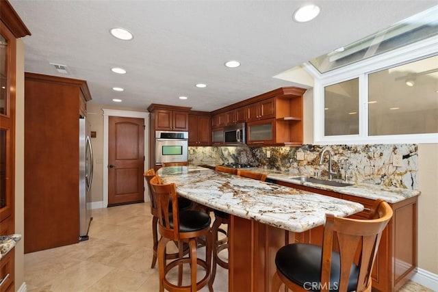 33551 Sandcastle Ct, Dana Point, CA 92629 - kitchen with stainless steel appliances, decorative backsplash, a center island, a breakfast bar area, and open shelves