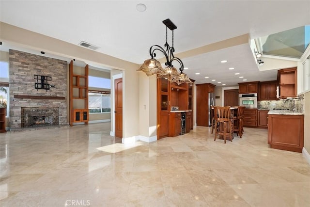 33551 Sandcastle Ct, Dana Point, CA 92629 - kitchen with stainless steel oven, open shelves, open floor plan, tasteful backsplash, and a fireplace
