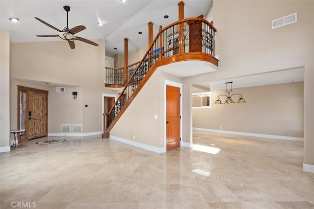 33551 Sandcastle Ct, Dana Point, CA 92629 - unfurnished living room featuring ceiling fan, stairs, a towering ceiling, a chandelier, and marble finish flooring