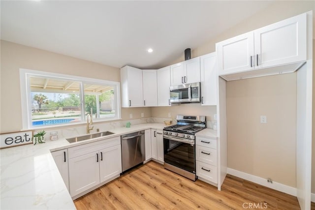 11617 Low Chaparral Dr, Victorville, CA 92392 - kitchen with stainless steel appliances, light stone counters, white cabinets, light wood finished floors, and recessed lighting