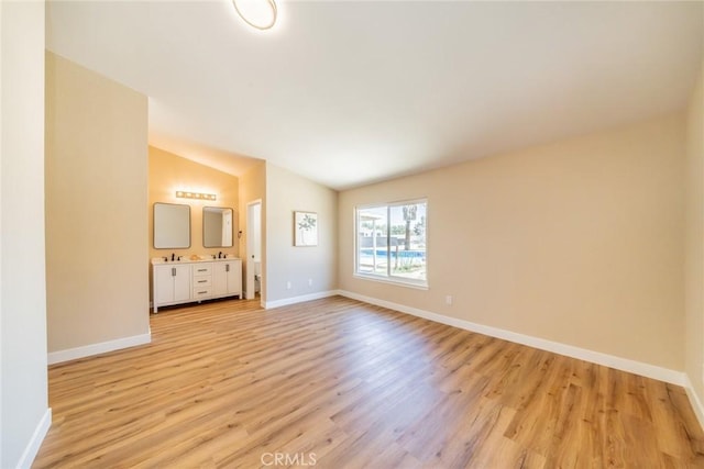 11617 Low Chaparral Dr, Victorville, CA 92392 - unfurnished living room with light wood-style flooring and vaulted ceiling