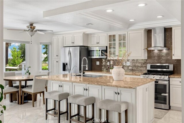 5999 Cedar Mountain Dr, Rancho Cucamonga, CA 91737 - kitchen featuring stainless steel appliances, wall chimney exhaust hood, tasteful backsplash, a breakfast bar area, and a tray ceiling