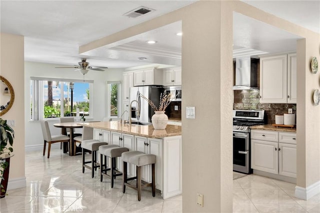 5999 Cedar Mountain Dr, Rancho Cucamonga, CA 91737 - kitchen with appliances with stainless steel finishes, wall chimney range hood, decorative backsplash, a breakfast bar area, and light stone counters