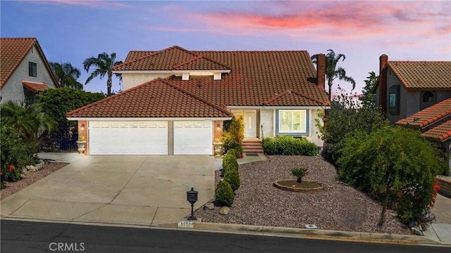 5999 Cedar Mountain Dr, Rancho Cucamonga, CA 91737 - mediterranean / spanish-style home featuring a tiled roof, an attached garage, concrete driveway, a chimney, and stucco siding