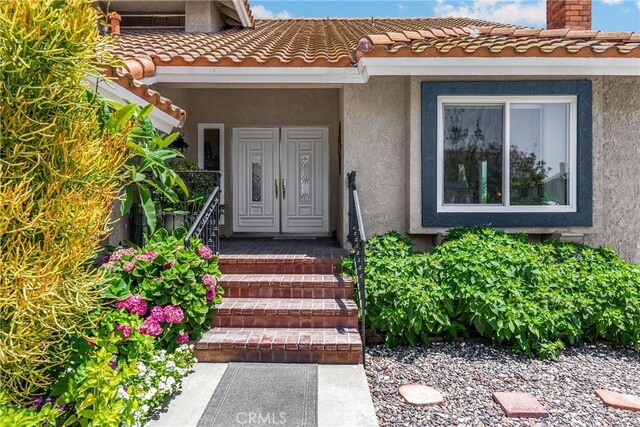 5999 Cedar Mountain Dr, Rancho Cucamonga, CA 91737 - doorway to property featuring stucco siding, a chimney, and a tiled roof