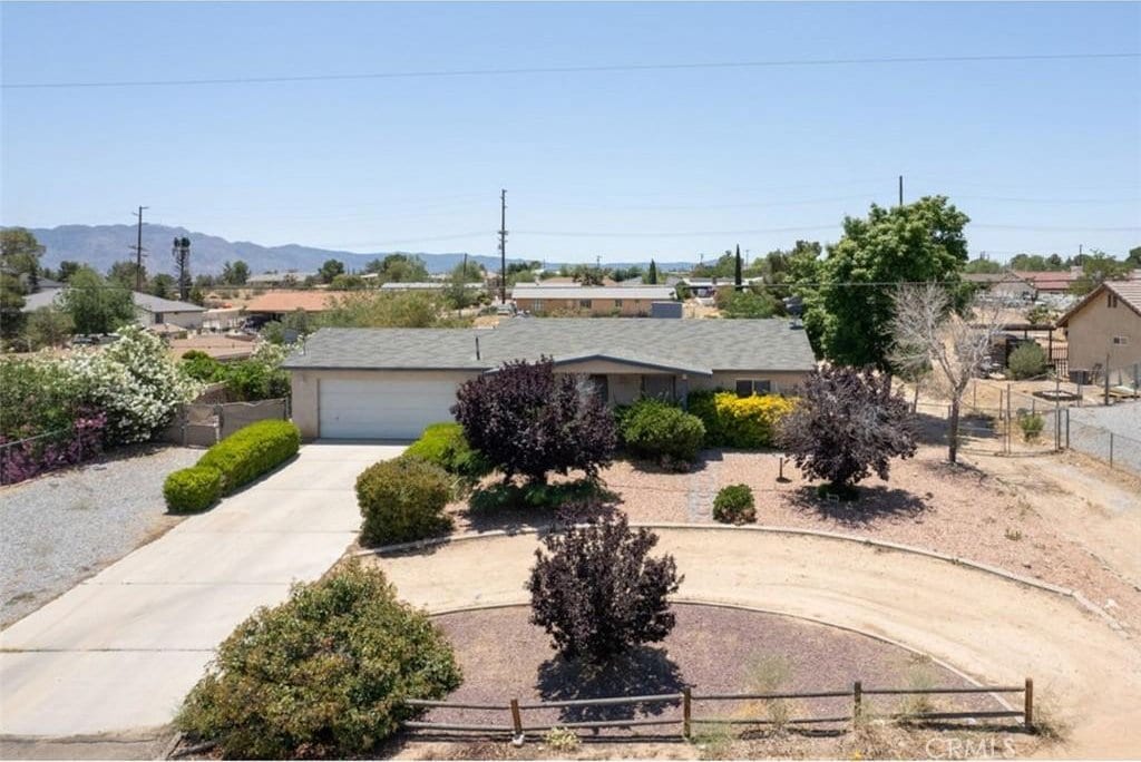 18563 Yucca St, Hesperia, CA 92345 - view of front of house with curved driveway, a mountain view, and an attached garage