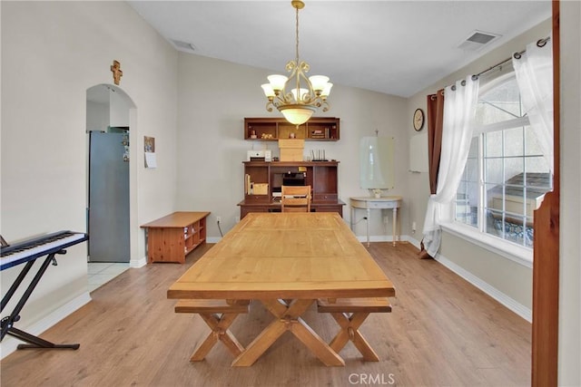 7330 Smoke Tree Rd, Phelan, CA 92371 - dining room featuring vaulted ceiling, arched walkways, light wood-style flooring, and a chandelier
