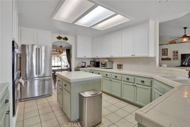 7330 Smoke Tree Rd, Phelan, CA 92371 - kitchen with appliances with stainless steel finishes, light tile patterned floors, tile counters, and green cabinetry