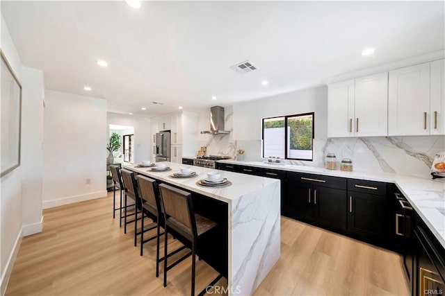 1603 Sunnyside, San Pedro, CA 90732 - kitchen featuring wall chimney exhaust hood, dark cabinets, a breakfast bar, white cabinetry, and stainless steel refrigerator with ice dispenser