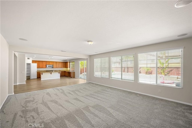 36845 Gemina Ave, Murrieta, CA 92563 - unfurnished living room featuring light colored carpet and a textured ceiling