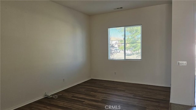 9019 Fremont Ct, Oak Hills, CA 92344 - empty room with plenty of natural light and dark wood-style flooring