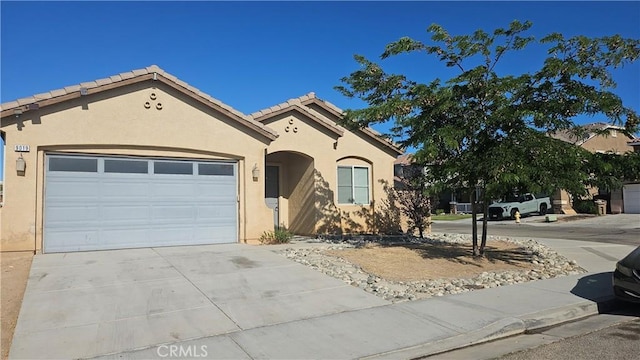 9019 Fremont Ct, Oak Hills, CA 92344 - mediterranean / spanish-style house featuring stucco siding, concrete driveway, an attached garage, and a tile roof