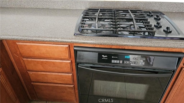 9019 Fremont Ct, Oak Hills, CA 92344 - kitchen view of gas cooktop, black oven, and brown cabinets