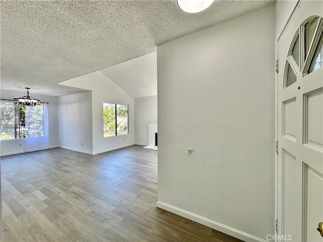 2568 Highgate Ct, Chino Hills, CA 91709 - unfurnished room featuring a textured ceiling, a chandelier, plenty of natural light, wood finished floors, and vaulted ceiling