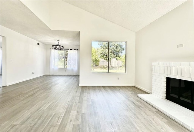 2568 Highgate Ct, Chino Hills, CA 91709 - unfurnished living room featuring a textured ceiling, wood finished floors, a chandelier, a fireplace, and high vaulted ceiling