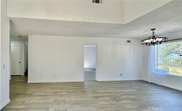 2568 Highgate Ct, Chino Hills, CA 91709 - spare room with a textured ceiling, light wood finished floors, and a chandelier