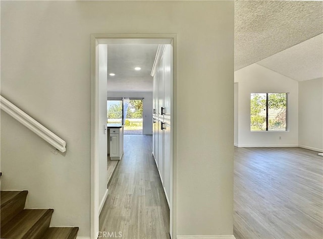 2568 Highgate Ct, Chino Hills, CA 91709 - corridor with light wood finished floors, a textured ceiling, vaulted ceiling, recessed lighting, and stairs