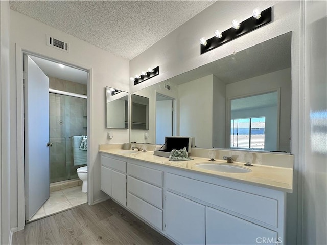 2568 Highgate Ct, Chino Hills, CA 91709 - full bathroom featuring a shower stall, double vanity, a textured ceiling, and wood finished floors