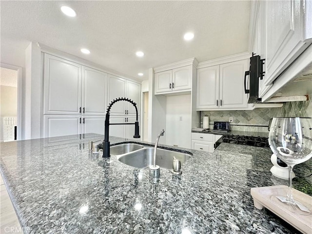 2568 Highgate Ct, Chino Hills, CA 91709 - kitchen featuring dark stone countertops, black microwave, white cabinets, tasteful backsplash, and a peninsula