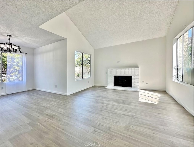 2568 Highgate Ct, Chino Hills, CA 91709 - unfurnished living room featuring a textured ceiling, a chandelier, vaulted ceiling, wood finished floors, and a fireplace
