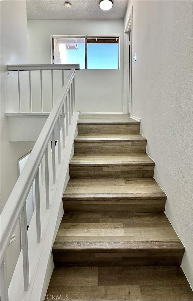 2568 Highgate Ct, Chino Hills, CA 91709 - stairs with a textured ceiling and wood finished floors